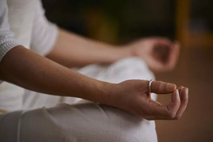 personne entrain de méditer mais sur les genoux en chin mudra